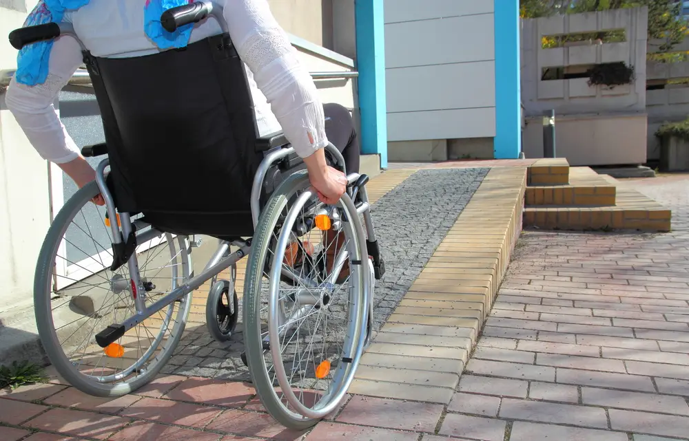 איש עם כיסא גלגלים עולה על רמפה